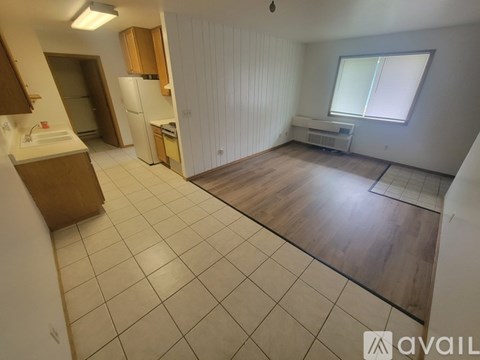 A kitchen with white appliances and wooden cabinets.
