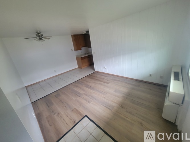 A room with wooden flooring and a ceiling fan.