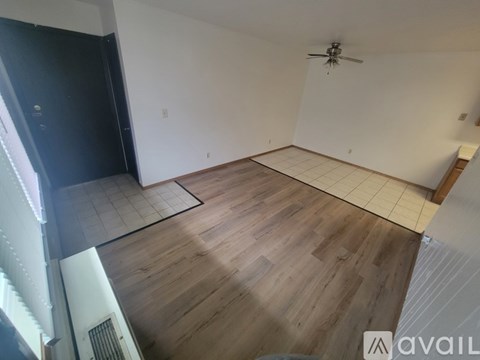 A room with wooden flooring and a ceiling fan.