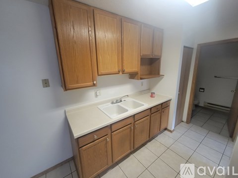 A kitchen with wooden cabinets and a white sink.