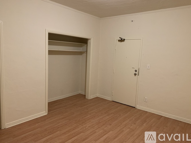A room with a door, a shelf, and a window.