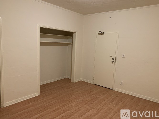 A room with a door, a shelf, and a window.