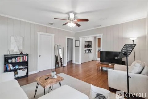 A living room with a white couch and a wooden coffee table.