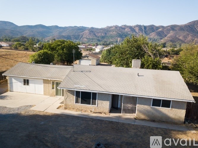 A house with a mountain range in the background is for sale.