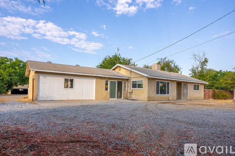 A house with a gravel driveway in front of it is for sale.