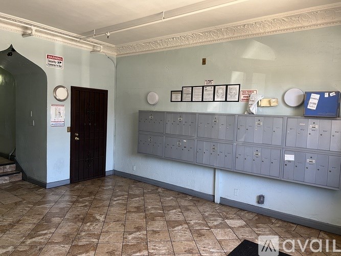 A room with a brown door and a wall of electrical boxes.