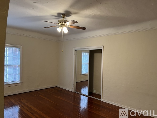 A room with a ceiling fan and wooden floors.