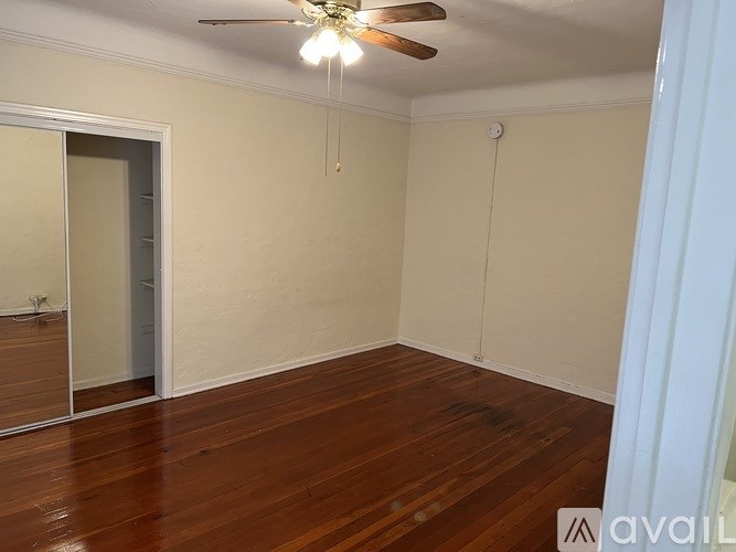 A room with wooden floors and a ceiling fan.