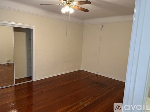 A room with wooden floors and a ceiling fan.