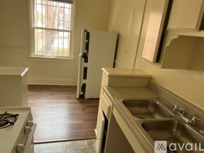 A kitchen with a stove, sink and refrigerator.