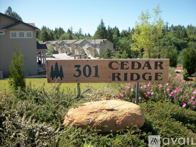 A sign for Cedar Ridge stands in front of a house.