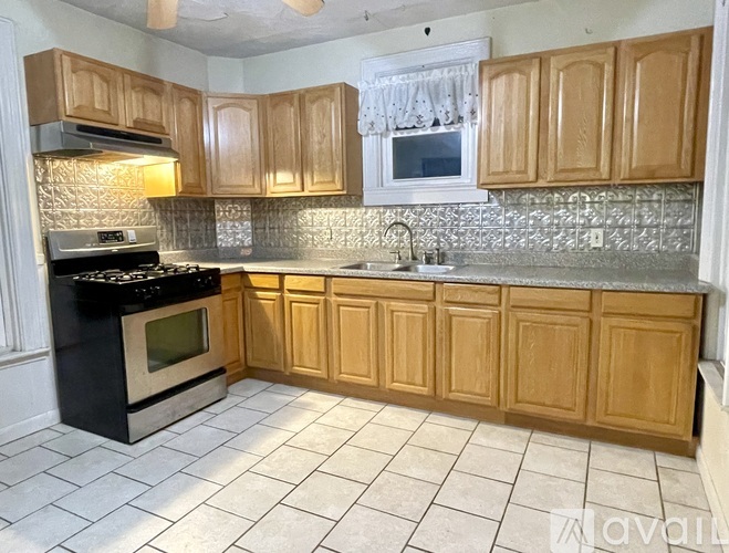 A kitchen with wooden cabinets and a black stove top oven.