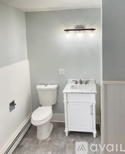 A white toilet and sink in a small bathroom.