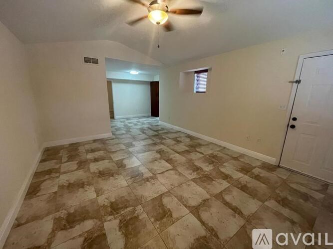 A room with a ceiling fan and tiled flooring.