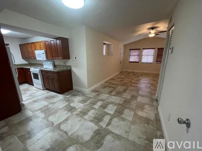 A kitchen with a tile floor and a ceiling fan.