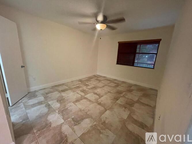 A room with a ceiling fan and tiled floor.