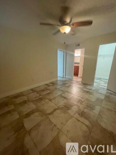 A room with a fan and tiled flooring.