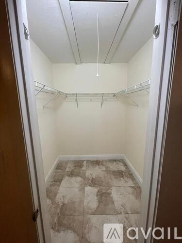 A small, empty room with a marble floor and a couple of shelves.