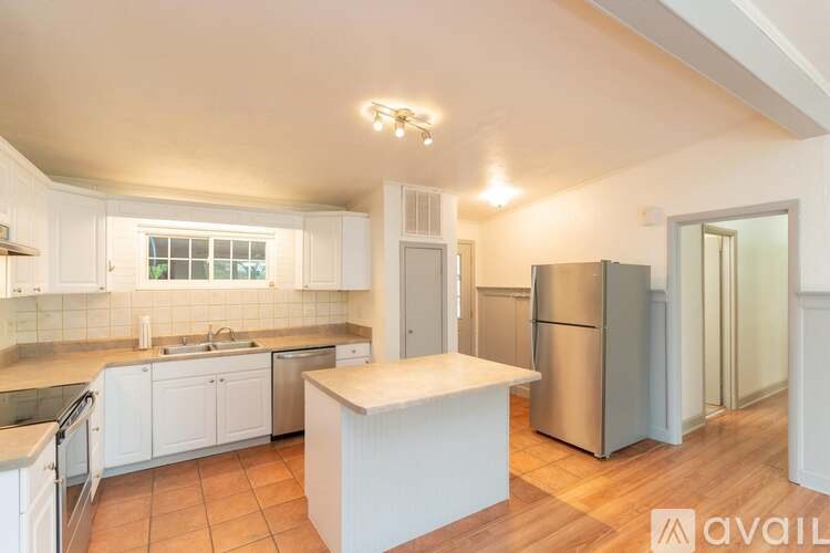 A kitchen with white cabinets and a wooden island.