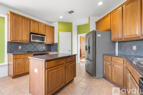A kitchen with wooden cabinets and a black countertop.