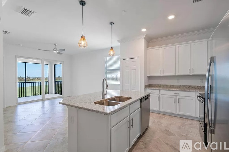 A kitchen with white cabinets and a marble countertop.
