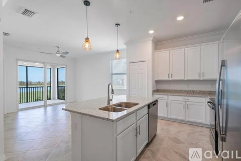 A kitchen with white cabinets and a marble countertop.