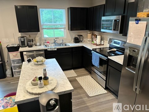 A kitchen with black cabinets and stainless steel appliances.