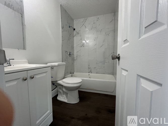 A white bathroom with a toilet, sink, and bathtub.