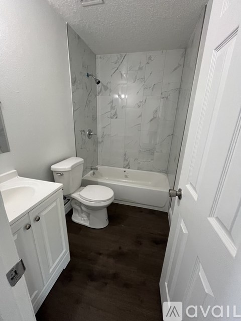 A bathroom with a marble wall and a white toilet.