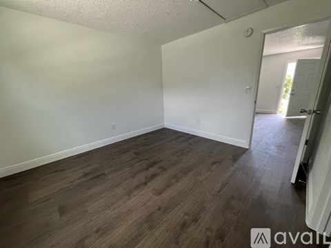 A room with wooden flooring and white walls.