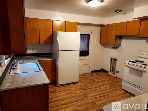 A kitchen with wooden cabinets and a white fridge.