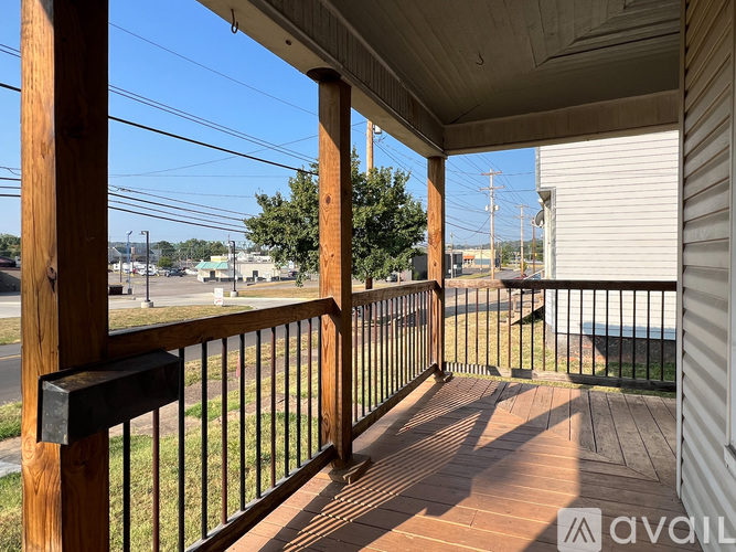 A wooden deck with a black railing and a mailbox.