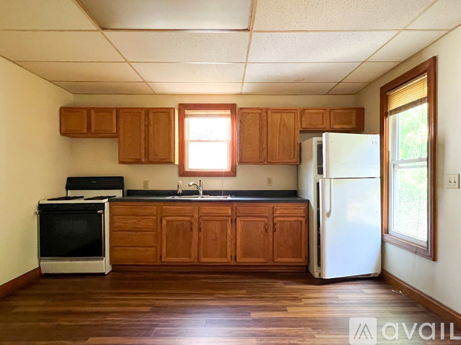 A kitchen with wooden cabinets and a white refrigerator.