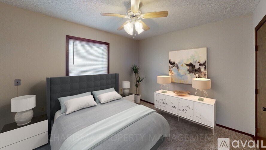 A bedroom with a bed, nightstand, and a ceiling fan.