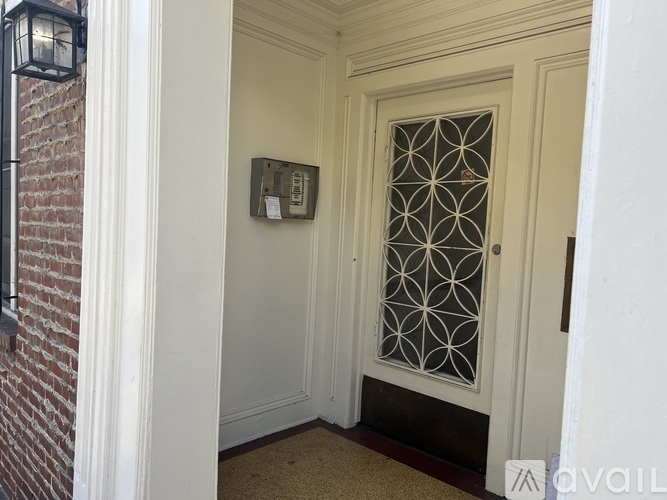 A white door with a glass window and a metal grill design.