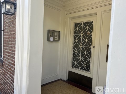 A white door with a glass window and a metal grill design.