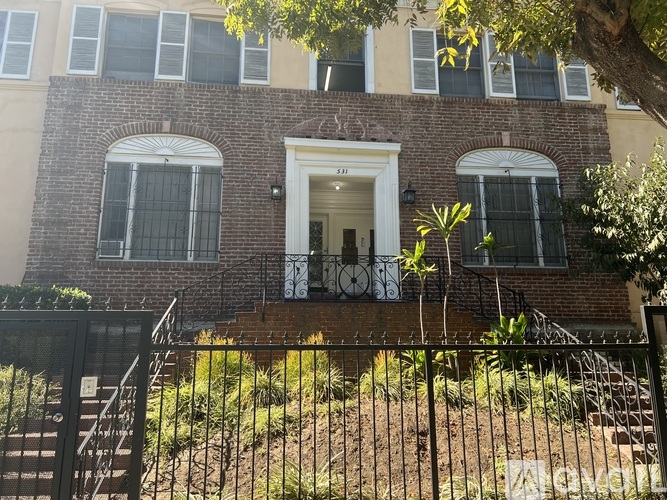 A brick building with a white door and windows.