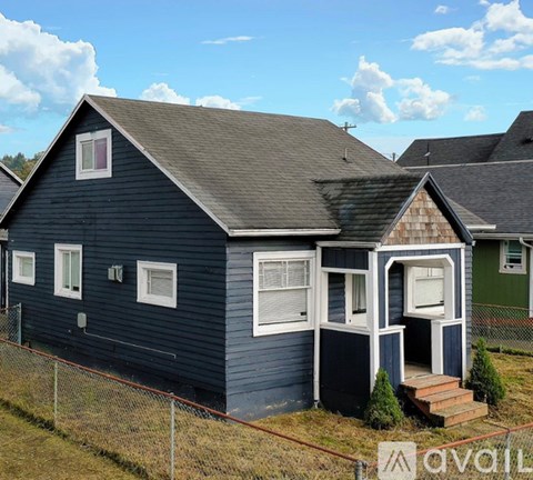 A blue house with a white window and a brown door.
