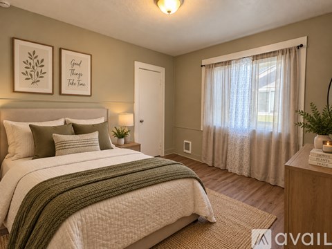 A room with wooden flooring and a window with curtains.