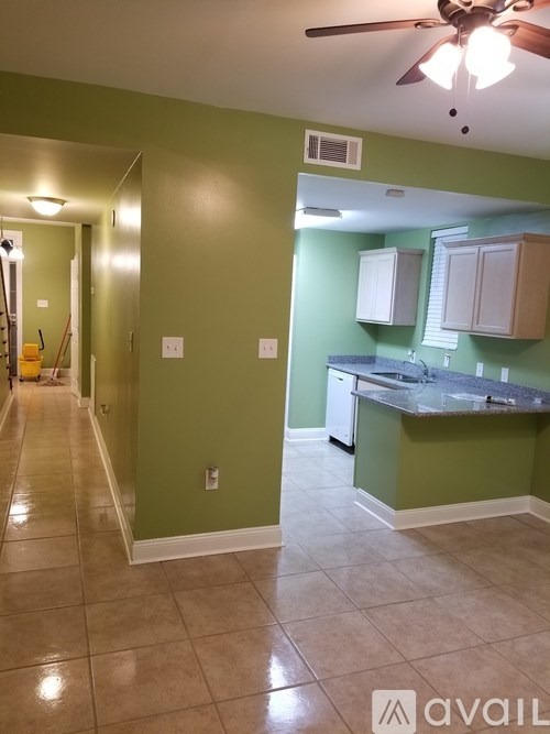 A kitchen with green walls and a tiled floor.