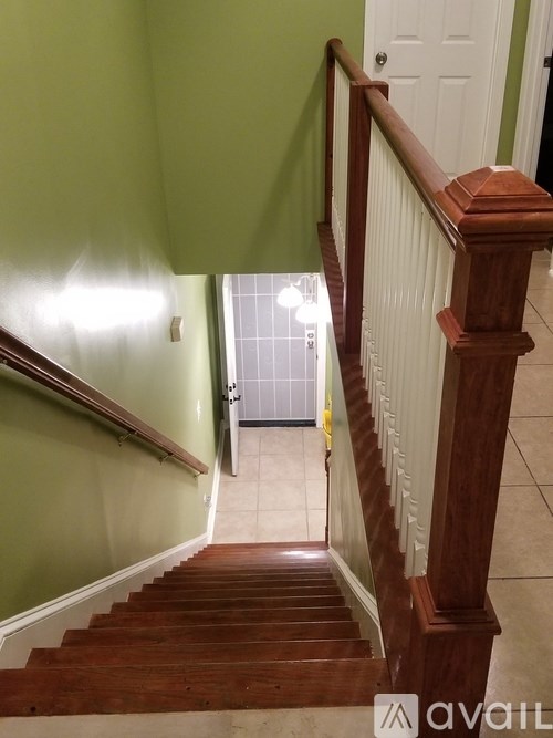 A staircase with a green wall and a white door at the top.