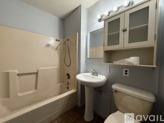 A bathroom with a white toilet, sink, and bathtub.