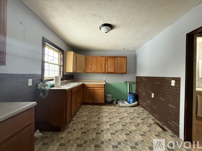 A kitchen with brown cabinets and a tiled floor.