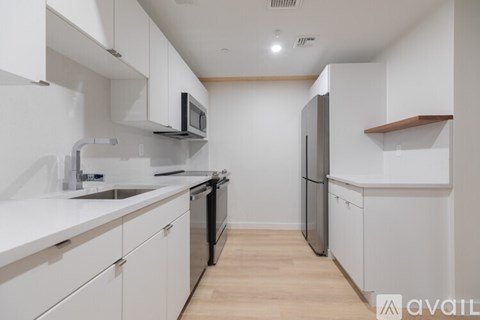 A kitchen with white cabinets and a wooden floor.