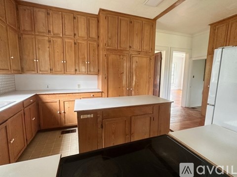 A kitchen with wooden cabinets and a white countertop.