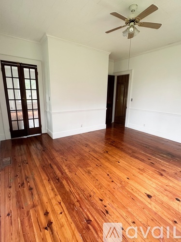 A room with wooden floors and a ceiling fan.