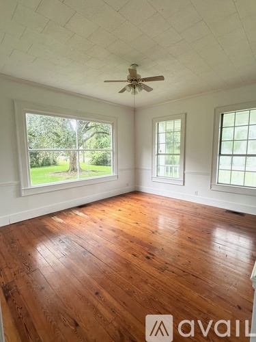 A room with wooden floors and a ceiling fan.