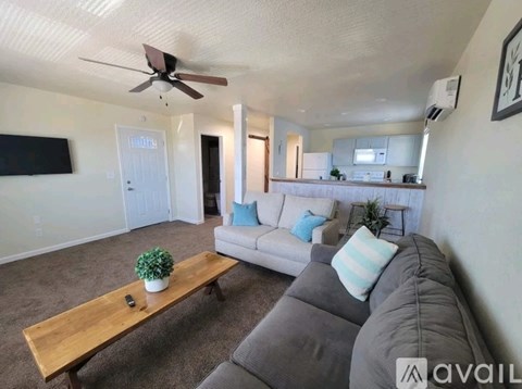 A living room with a grey couch and a wooden coffee table.