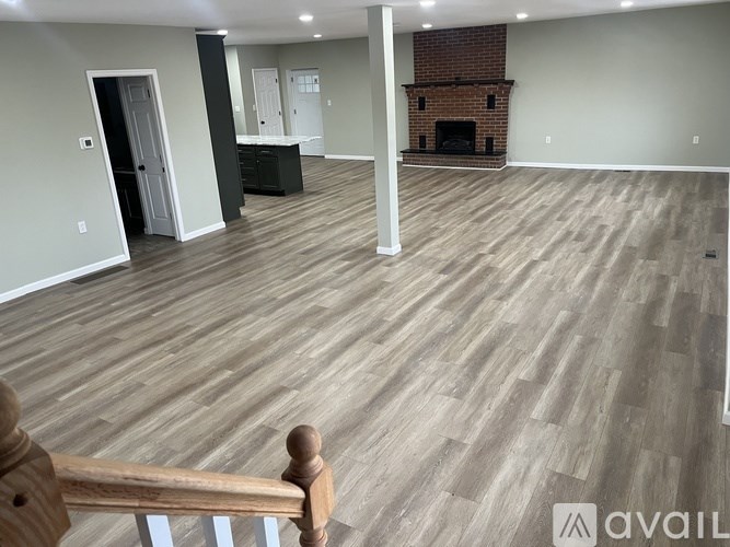 A room with a fireplace and wooden flooring.