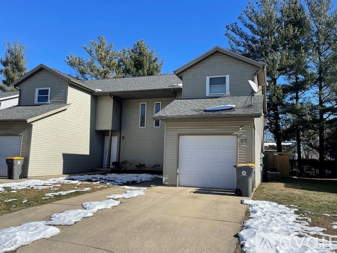 A house with a garage and a driveway in front.